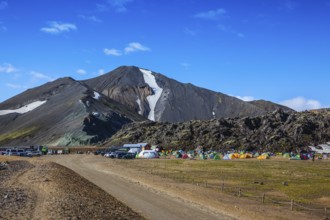 Rhyolite mountains surround the flat valley of National Park Landmannalaugar. Big tourist camp is