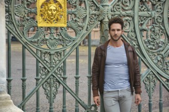 A man standing in front of a green gate in Piazza Castello in Turin, Italy, Europe