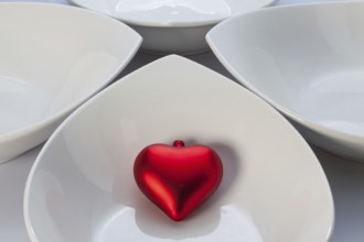Four white ceramics bowls and red heart