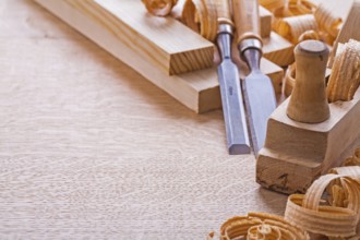 Organized copspace woodworkers plane carpentry chisels shavings on wooden board construction