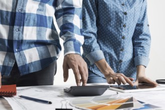 Designers working with color swatches and tablet computer at desk. Interior design, architectural