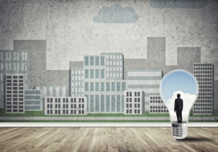 Businessman inside light bulb against city drawn concept