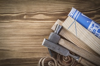 Blue blueprint claw hammer chisel wooden studs curled shavings on wood board
