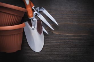 Clay gardening pots trowel fork and hand spade on vintage wood board agriculture concept