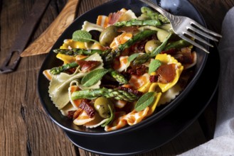 Pasta salad with green asparagus, olives and Parma ham