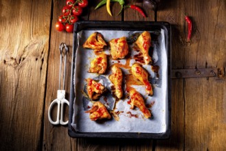 Rustic backed chicken wings, legs on baking tray