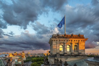 The Berlin Reichstag with evening sky with the flag of Europe and clouds in the background. The
