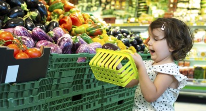 Child shopping eggplants in supermarket. Concept for buying fruits and vegetables in hypermarket.