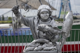 Detailed silver statue of a fisherwoman with fish, Hamburg harbour, Free and Hanseatic City of