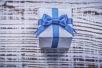 Present box on vintage wooden board top view holidays concept