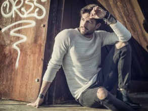 One handsome young man in urban setting in European city, standing