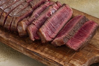 Freshly sliced steak, medium roast, on a wooden cutting board, with a juicy texture and rich color,