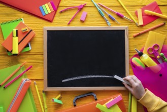 Back to school supplies arrangement vivid colorful neon color and blackboard hand chalk
