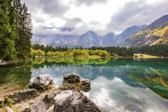 Gorgeous reflections. Picturesque lake Fusine in Northern Italy. Mountains covered in mist. The
