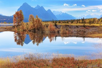 Smooth water of artificial lake Abraham reflects the Rocky Mountains. Sunny day in October.
