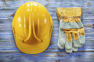 Safety gloves building helmet on vintage wooden board