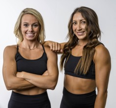 Two gorgeous athletic fit models pose confidently, their toned muscles highlighted by soft lighting
