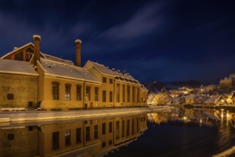 Winter view of Cesky Krumlov, picturesque houses under the castle with snow-covered roofs. Narrow