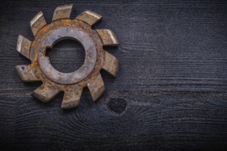 Vintage milling cutter with cogs on wood board construction concept