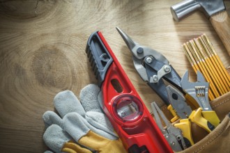 Set of construction tooling in toolbelt on wooden board