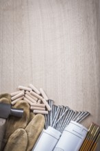 Set of wooden meter dowels construction plans claw hammer leather safety gloves and metal nails on