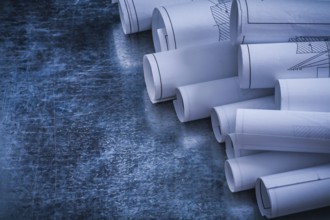 Metallic vintage background with heap of white blueprint rolls building and architecture concept