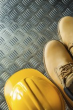 Waterproof boots building helmet on corrugated metal sheet