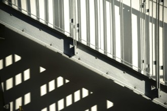 The façade of a residential building with an external staircase that casts a shadow