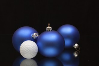 Blue Christmas decoration a golf balls on a black glass desk