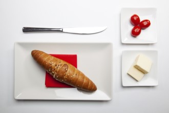 Healthy breakfast. Block of fresh butter, french baguette and red cherry tomatoes on the white