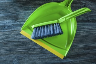 Plastic dustpan and brush set on wooden board