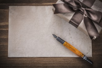 Present box brown bow paper fountain pen on wood board