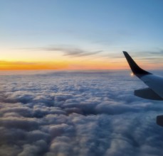 View from an aeroplane at sunset over a cloud cover