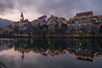 Christmas illuminated house facade of Frohnleiten reflected in the river Mur, Frohnleiten, Styria,