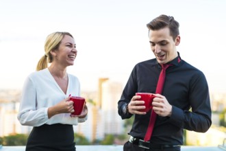 Couple of caucasian businessmen, young attractive brunette man in dark suit, red tie and black