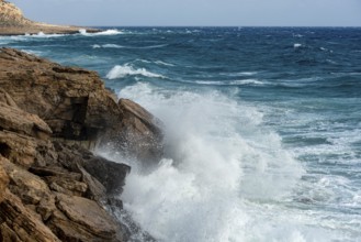 Waves crashing on rocky coast. Windy weather, Powerful sea waves braking on rocks