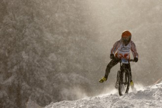Sofia, Bulgaria - 22 January, 2022: Cyclist rides a bike downhill during an extreme snow riding