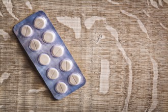Pills in blister pack on vintage wooden board with organized copyspace medical concept