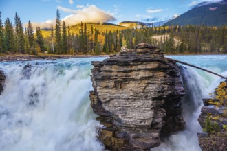 Powerful and scenic Athabasca Falls. Sunset illuminates the surrounding mountains. Canada, Jasper