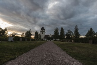 Rattvik, Dalarna, Sweden, 08 05 2019: View over the cloudes graveyard and the small church at dusk,