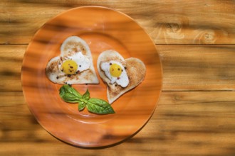 Breakfast of toast and eggs in the shape of heart