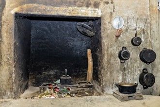 Old fireplace with hanging pots and pans, rustic ambience with traces of soot and a scale on the