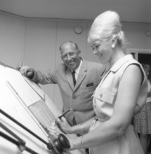 Chocolate in the 1960s. A woman in an office has her hair in the typical Beehive hairstyle, in