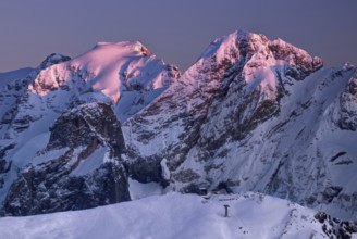 View from the top of Marmolada on the surrounding Dolomite hills after sunrise in winter