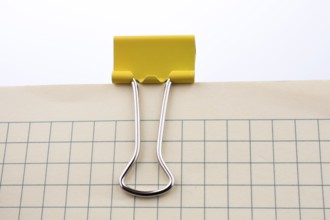 Colored paper clip on a checked notebook page