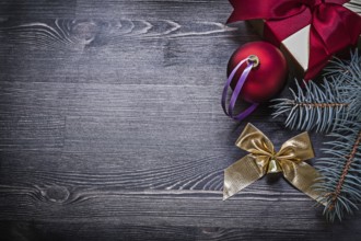 Christmas bauble bow fir twig present box on wood board