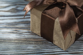 Brown gift box with tied bow on a wooden background