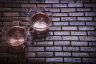 Coppery teacups on wooden mat Food and drink concept