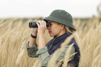 Adult woman outdoors with binoculars