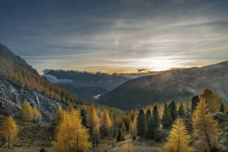 Sunset on a foggy autumn evening overlooking the valley at the Valles pass in the italian Dolomites